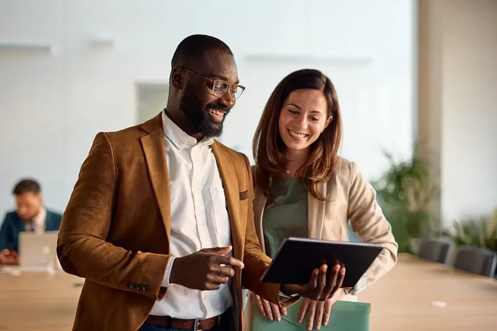 Two colleagues reviewing work together on a tablet
